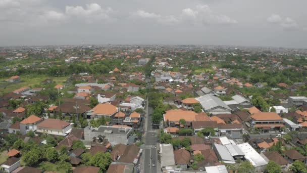 Coches y bicicletas en la carretera en la ciudad de Canggu Bali isla 4K vuelo Drone — Vídeo de stock