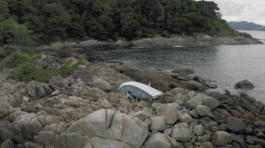 Storm 'dan sonra kayalıklarda kırık bir yat, denizde batık bir kız.