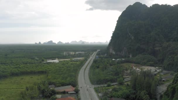 Autostrada między górami a tropikalnym lasem w Azji, Tajlandii, 4k strzał drona — Wideo stockowe