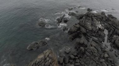 Tayland 'da kıyı şeridi, kayalıklarda kırılan okyanus dalgaları, 4k İHA uçuşu.