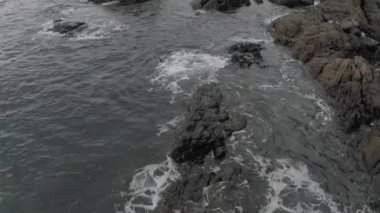 Tayland 'da kıyı şeridi, kayalıklarda kırılan okyanus dalgaları, 4k İHA uçuşu.