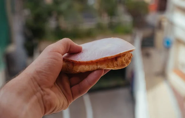 Sándwich sabroso con jamón y ensalada en la mano — Foto de Stock