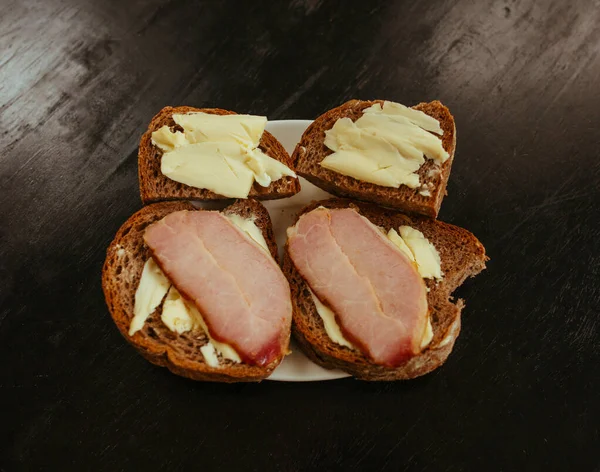 Desayuno, pan negro Sandwich con zumbido sobre mesa negra — Foto de Stock