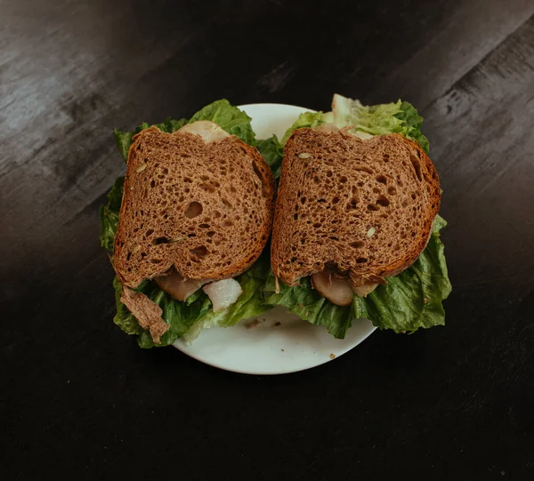 Sandwich con zumbido y ensalada sobre mesa negra — Foto de Stock