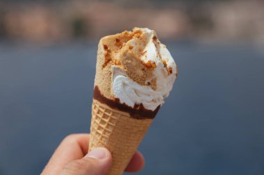 Dondurma ve waffle fincanı, erkeklerin elinde yatta.