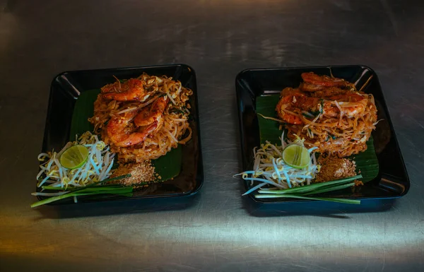 Almohadilla de fideos tailandeses con mariscos y nueces en la mesa —  Fotos de Stock