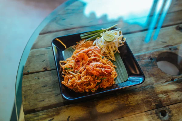 Almohadilla de fideos tailandeses con mariscos y nueces en la mesa — Foto de Stock