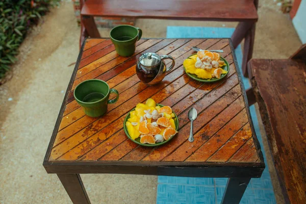 Chá quente, manga fresca, mangostão e tangerinas na mesa de madeira — Fotografia de Stock
