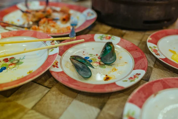 Mejillones vacíos sobre la mesa después de la cena en Asia —  Fotos de Stock