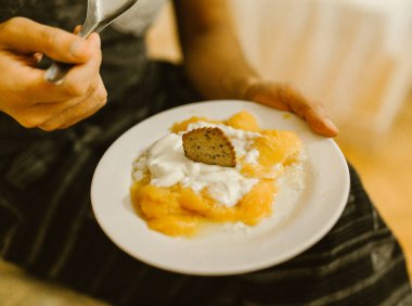 Otelde yoğurtlu ve kaşıklı mango meyvesi.