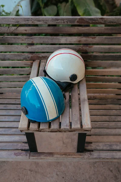 Велосипедные шлемы на деревянной скамейке в Азии — стоковое фото