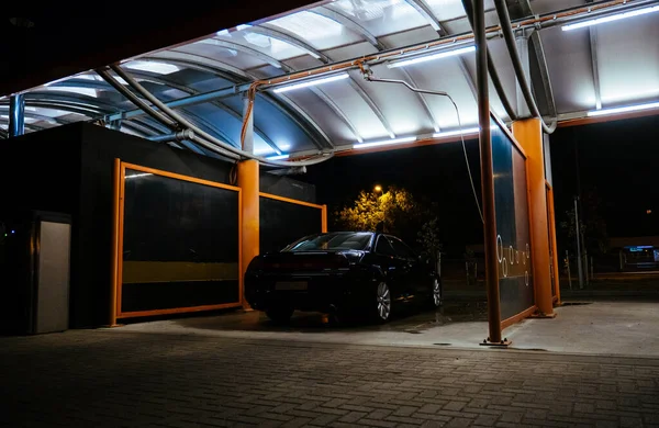 Автомойка ночью черный автомобиль и лампы освещения — стоковое фото