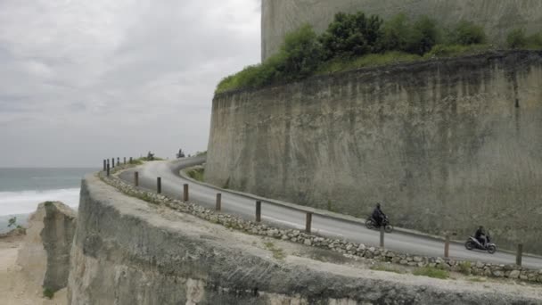 Bicicleta na estrada em montanhas Uluwatu Bali praia e rochas — Vídeo de Stock