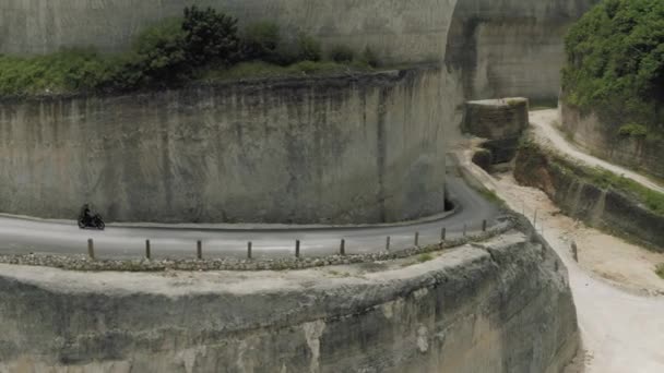 Bicicleta en la carretera en las montañas Uluwatu Bali playa y rocas — Vídeos de Stock