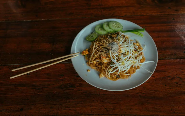 Almohadilla de fideos tailandeses con pollo y pepinos y palitos de bambú — Foto de Stock