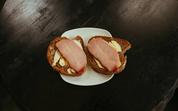 Desayuno, pan negro Sandwich con zumbido sobre mesa negra — Foto de Stock