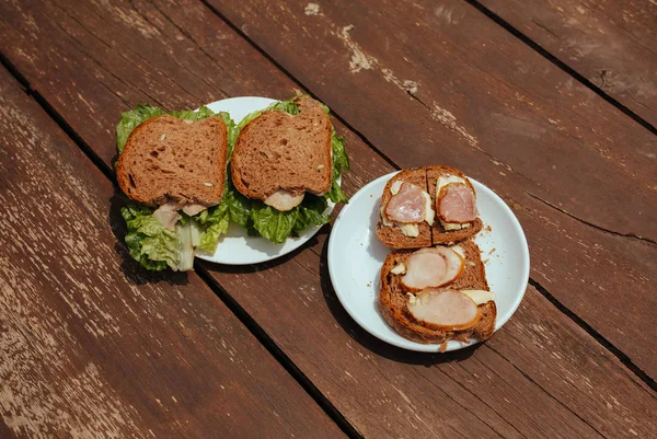 Sandwich con zumbido y ensalada en un banco de madera — Foto de Stock