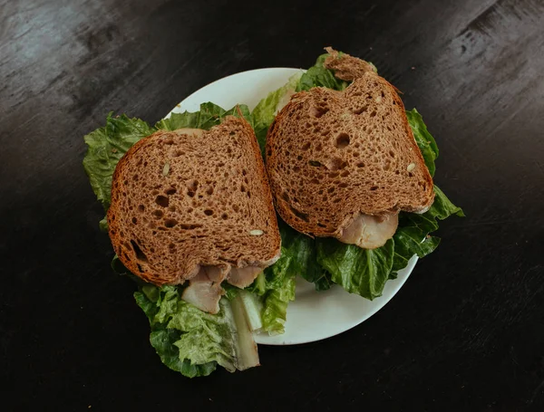 Sandwich con zumbido y ensalada sobre mesa negra — Foto de Stock
