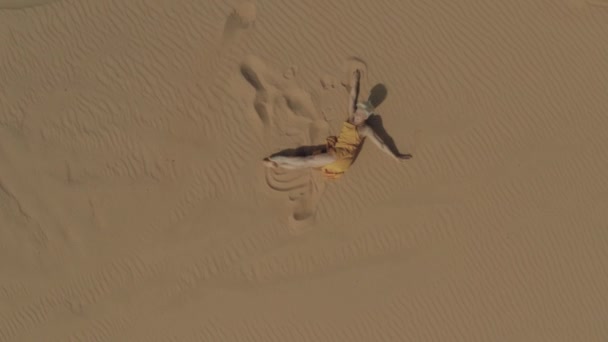 Девушка танцует на песчаных дюнах, дрон-кадр 4К — стоковое видео