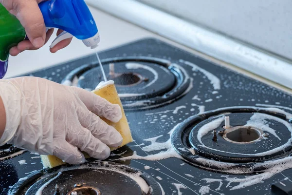 Cleaning a gas stove with kitchen utensils, household concepts, or hygiene and cleaning.