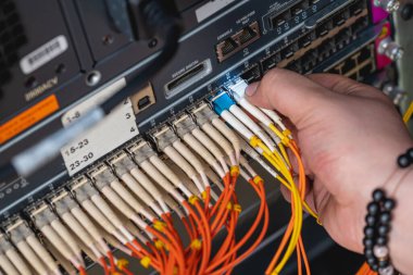 Dijital iletişim ve internet için fiber optik merkezi olan ağ sunucu odasında çalışan adam