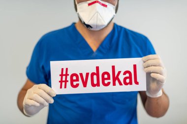 Evde Kal (Türkçe - İngilizce çevirisi: evde kal) adlı bir doktor elinde tutarak Coronavirus veya Covid-19 salgınından korur.