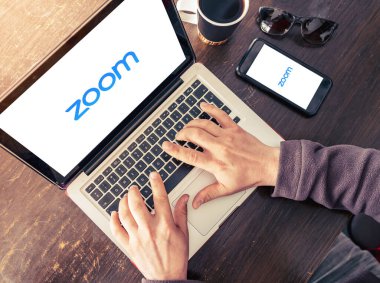 Bilgisayarda ve cep telefonunda Zoom Cloud Toplantı uygulamasının logosu görünüyor. Antalya, Turkey - 30 Mart 2020.