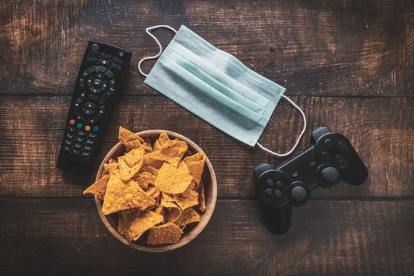 Remote Control Game Console Bowl Crisps Medical Mask Wooden Table — Stock Photo, Image