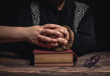 Kutsal kitap üzerine tespih çeken kız ve yaşlı kadın evde kalıp korunmak için dua ediyorlar. Yaşlılık koronavirüsü covid-19 pandemi konsepti..
