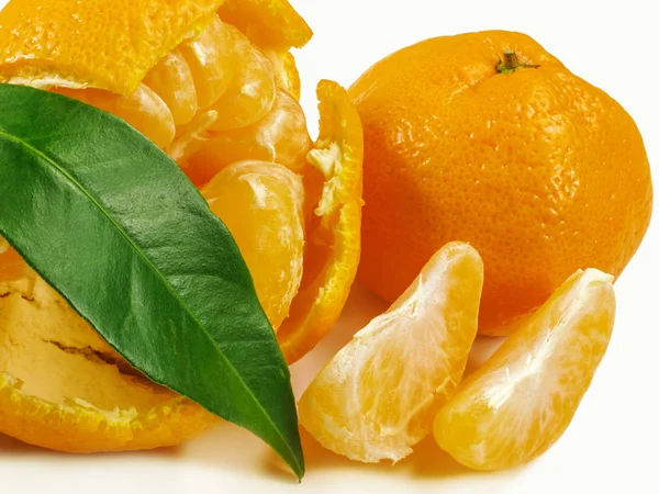 Mandarynka, mandarin obrane plastry i zielony liść. — Zdjęcie stockowe