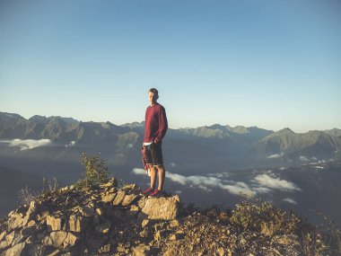 sırt çantası ayakta bulut üzerinde dağ tepesinde olan adam portresi