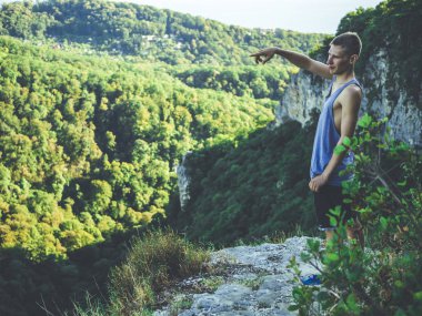 mountai kenarına parmakla işaret eden adam portresi