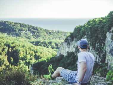 mountai kenarında oturan adam portresi