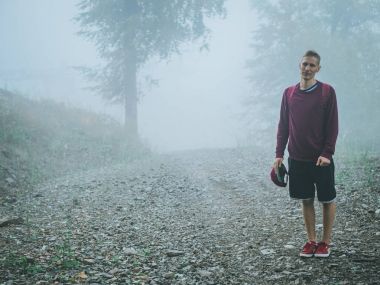 sis Dağı'nda sırt çantası ayakta sırasında yağmur, bulutlu adam adam portresi