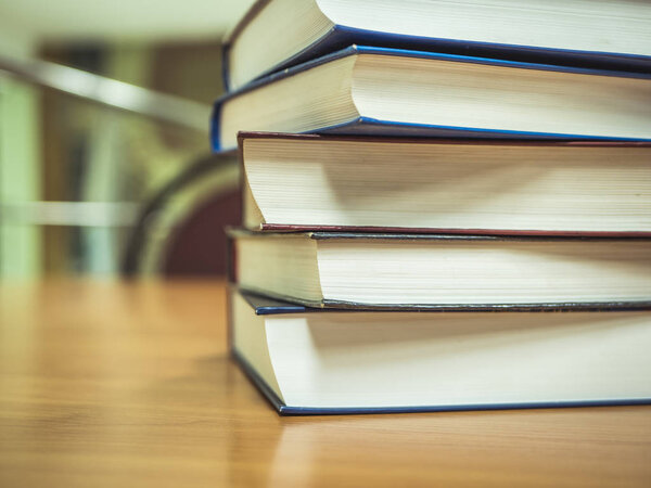 крупным планом стопки книг на столе в либраре
