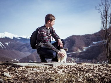 dağda kedi ile oynarken sırt çantası ile turizm 