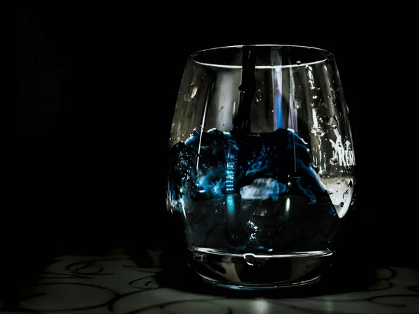 ガラス テーブル 黒の背景上に青い水ドロップ — ストック写真