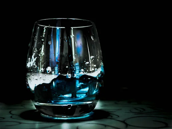 ガラス テーブル 黒の背景上に青い水ドロップ — ストック写真