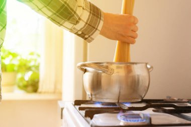 Eller, makarna demetini mutfaktaki yemek tepsisine koyar.