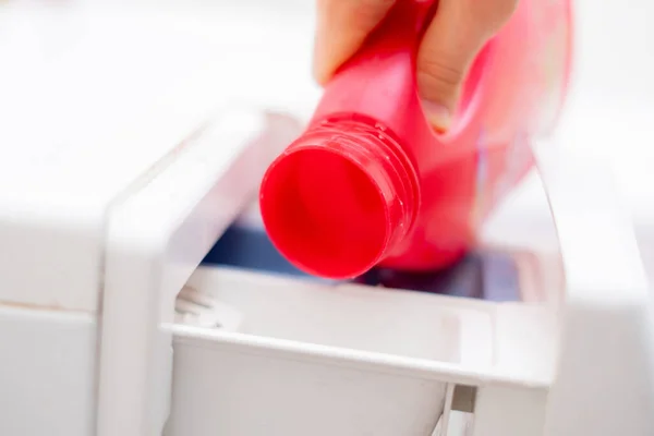 Derramando o condicionador de lavagem na máquina de lavar roupa para obter pano limpo — Fotografia de Stock