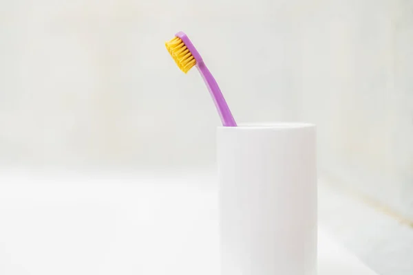 Satu sikat gigi sederhana dalam gelas di kamar mandi — Stok Foto