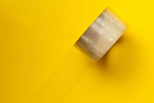 Rollo de cinta adhesiva en el fondo de color, caja del paquete para la entrega — Foto de Stock