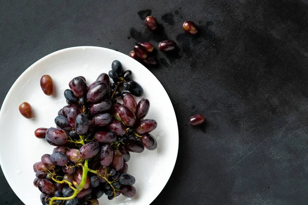 Felső nézet egy csomó szőlő bogyók vagy gyümölcsök a tányéron — Stock Fotó