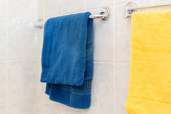 a colorful towel hang on the shelf hanger in bathroom s