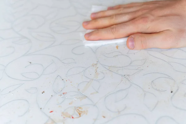 自宅のキッチンで汚れたテーブルの表面を拭く白い布で手 — ストック写真