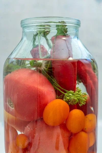 Macro shot of glass jar with pickled vegetables, tomatoes, cucumbers and herb — Stock Photo, Image