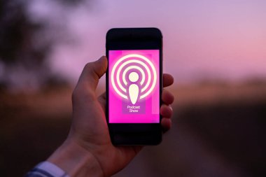Podcast simge uygulamaları ile akıllı telefonu tutan bir el
