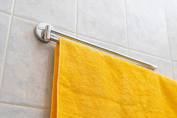 a colorful towel hang on the shelf hanger in bathroom