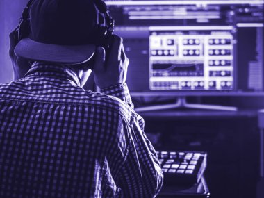 Geri planda ses mühendisi kafasında kulaklık tutuyor, 2020 yılındaki trend rengi, klasik mavi ton