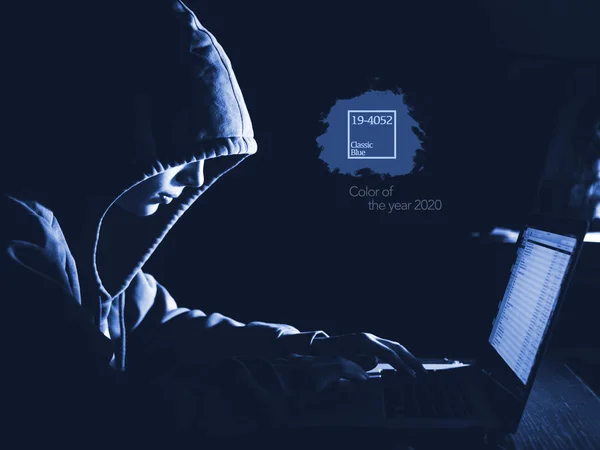 Anonimowy mężczyzna w kapturze w ciemnym studio wpisując tekst online w Internecie z miejsca do kopiowania — Zdjęcie stockowe